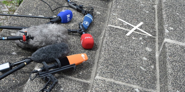 Mehrere Mikrofone liegen auf den Stufen einer Steintreppe im Freien Mehrere Mikrofone liegen auf den Stufen einer Steintreppe im Freien