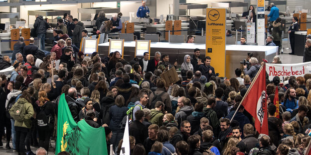 Eine Menschenmenge steht vor einem Flughafen Eine Menschenmenge steht vor einem Flughafen