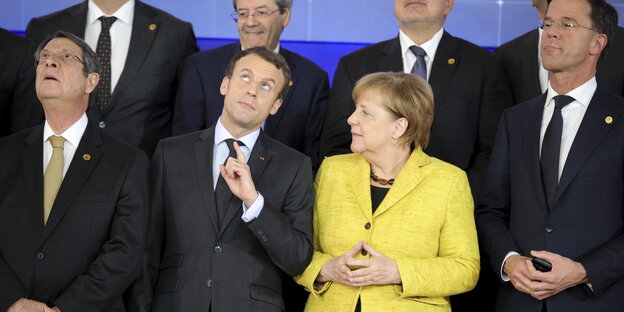 Der Präsident von Zypern, Nicos Anastasiades, der französische Präsident Emmanuel Macron und Bundeskanzlerin Angela Merkel (in gelb) blicken während eines Gruppenfotos im Rahmen des EU-Gipfels nach oben Der Präsident von Zypern, Nicos Anastasiades, der französische Präsident Emmanuel Macron und Bundeskanzlerin Angela Merkel (in gelb) blicken während eines Gruppenfotos im Rahmen des EU-Gipfels nach oben