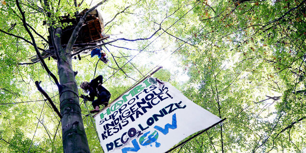 Plakate und Menschen in Baumkronen Plakate und Menschen in Baumkronen