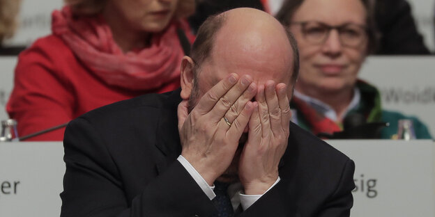 Ein Mann hält sich die Hände vors Gesicht Ein Mann hält sich die Hände vors Gesicht