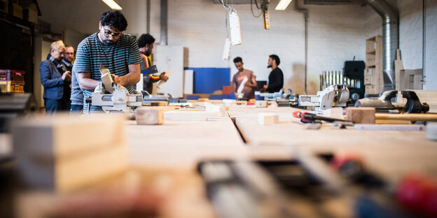 Menschen arbeiten in einer Werkstatt Menschen arbeiten in einer Werkstatt