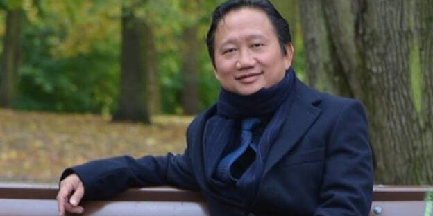 Trinh Xuan Thanh sitzt auf einer Parkbank Trinh Xuan Thanh sitzt auf einer Parkbank