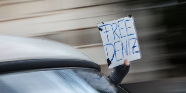 Aus einem fahrenden Auto hält jemand ein Schild mit der Aufschrift #Free Deniz Aus einem fahrenden Auto hält jemand ein Schild mit der Aufschrift #Free Deniz