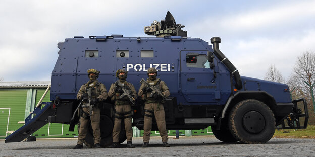 Bewaffnete Polizisten des SEK stehen vor dem Panzerwagen "Survivor R" Bewaffnete Polizisten des SEK stehen vor dem Panzerwagen "Survivor R"