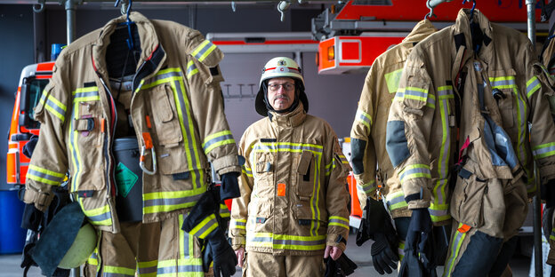 Porträt Rolf-Dieter Erbe in Uniform zwischen aufgehängten Uniformen Porträt Rolf-Dieter Erbe in Uniform zwischen aufgehängten Uniformen