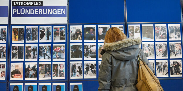 Eine Frau vor einem Aufsteller mit vielen Fotos Eine Frau vor einem Aufsteller mit vielen Fotos