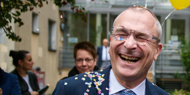 ein lachender Mann mit Konfetti auf dem Revers ein lachender Mann mit Konfetti auf dem Revers