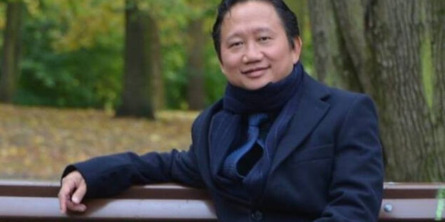 Trinh Xuan Thanh sitzt auf einer Bank Trinh Xuan Thanh sitzt auf einer Bank