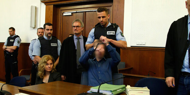Ein Justizvollzugsbeamter nimmt dem Angeklagten Sergej W. die Handschellen ab. Ein Justizvollzugsbeamter nimmt dem Angeklagten Sergej W. die Handschellen ab.