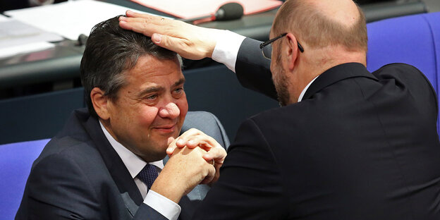 Sigmar Gabriel sitzt lächeln, Martin Schulz legt im die Hand auf den Kopf Sigmar Gabriel sitzt lächeln, Martin Schulz legt im die Hand auf den Kopf