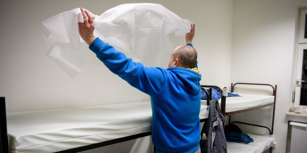 Mann bezieht ein Bett Mann bezieht ein Bett