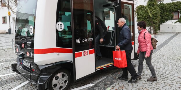Menschen steigen in einen kleinen Bus Menschen steigen in einen kleinen Bus