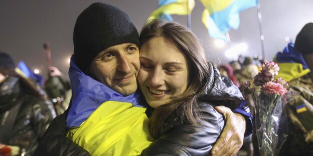 Freigelassener ukrainischer Soldat umarmt Frau Freigelassener ukrainischer Soldat umarmt Frau