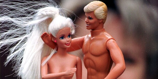 Ken und Barbie mit nackten Oberkörpern vor dem Gesicht eines Kindes Ken und Barbie mit nackten Oberkörpern vor dem Gesicht eines Kindes