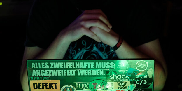 Gefaltete Hände vor einem Laptop Gefaltete Hände vor einem Laptop