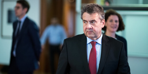 Sigmar Gabriel geht, hinter ihm steht mehrere Menschen Sigmar Gabriel geht, hinter ihm steht mehrere Menschen