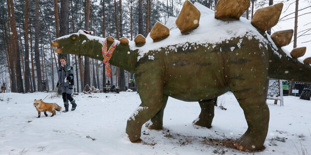 Eine Frau mit Fuchs an der Leine, ein Dino aus Stein Eine Frau mit Fuchs an der Leine, ein Dino aus Stein
