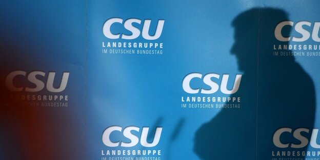 Der Schatten eines Mannes vor CSU-Schriftzügen Der Schatten eines Mannes vor CSU-Schriftzügen
