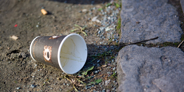 Einweg-Kaffeebecher auf dem Boden Einweg-Kaffeebecher auf dem Boden