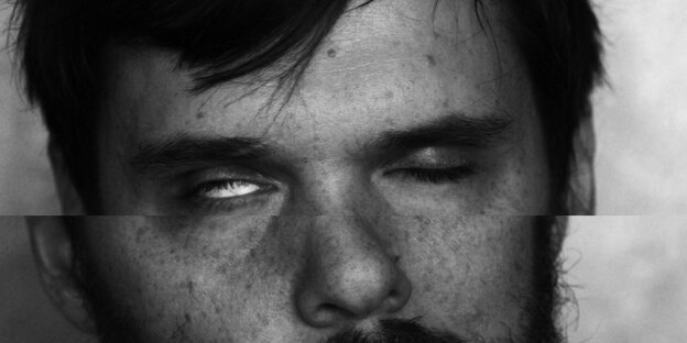 Ein Mann mit einem halb geöffneten Auge Ein Mann mit einem halb geöffneten Auge