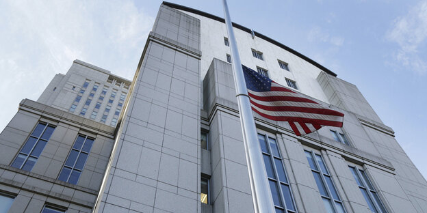 Die US-Flagge vor einem hohen Gebäude Die US-Flagge vor einem hohen Gebäude