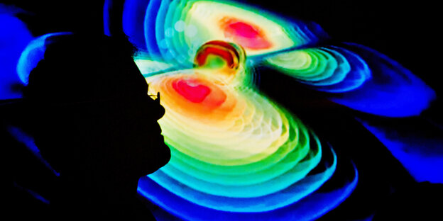 Umriss eines Mannes vor der grafischen Darstellung von Gravitationswellen Umriss eines Mannes vor der grafischen Darstellung von Gravitationswellen