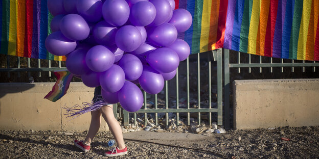 Eine Person ist hinter Luftballons versteckt Eine Person ist hinter Luftballons versteckt