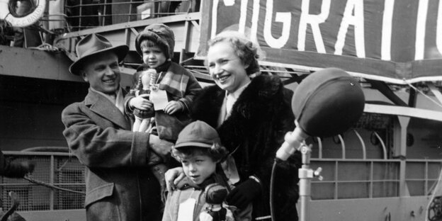 Eine Familie steht vor einem Schiff zum Einsteigen bereit.