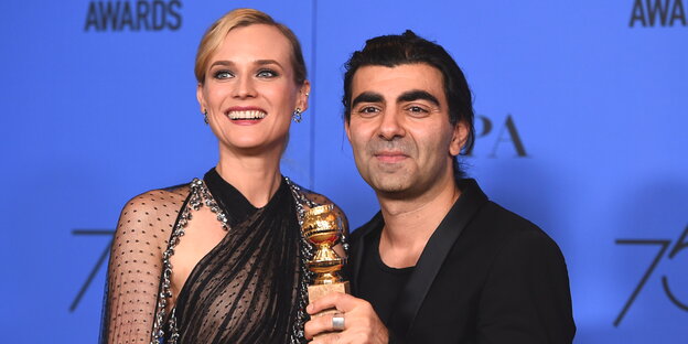 eine Frau und ein Mann mit einem goldenen Preis eine Frau und ein Mann mit einem goldenen Preis