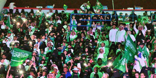 eine Menschenmenge mit vielen saudischen Fahnen eine Menschenmenge mit vielen saudischen Fahnen