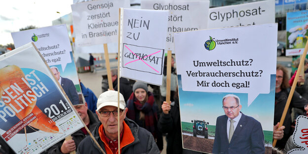 Eine Gruppe Menschen mit Schildern mit Glyphosat-kritischen Botschaften Eine Gruppe Menschen mit Schildern mit Glyphosat-kritischen Botschaften