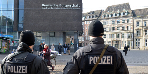 Zwei Männer in Polizeiuniform stehen vor der Bremischen Bürgerschaft. Zwei Männer in Polizeiuniform stehen vor der Bremischen Bürgerschaft.