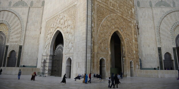 Menschen laufen in die berühmte Moschee Hassan II in Casablanca in Marokko Menschen laufen in die berühmte Moschee Hassan II in Casablanca in Marokko