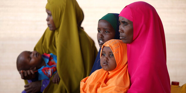 Zwei somalische Frauen mit bunten Kopftüchern und drei kleinen Kindern Zwei somalische Frauen mit bunten Kopftüchern und drei kleinen Kindern