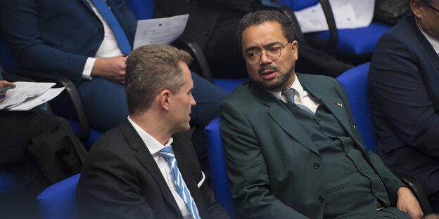 Zwei Männer sitzen im Bundestag und reden Zwei Männer sitzen im Bundestag und reden
