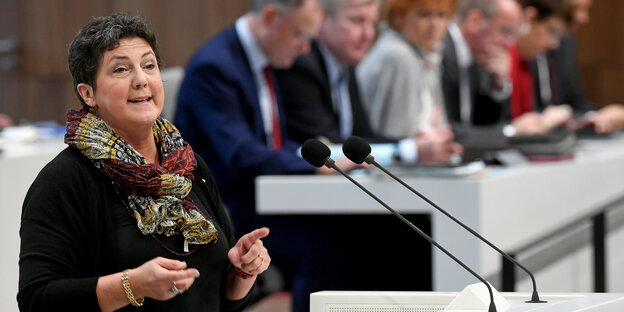 Anja Piel hinter einem Redner_innenpult Anja Piel hinter einem Redner_innenpult