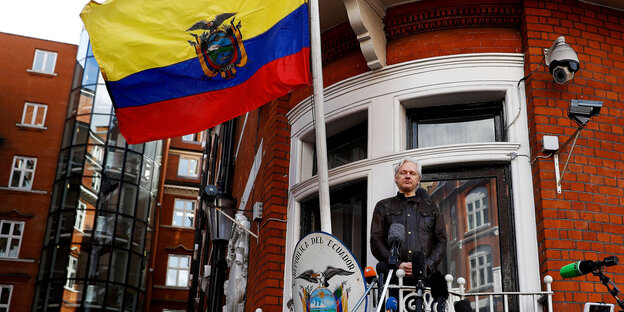 Ein Mann auf einem Balkon, über ihm weht die gelb-blau-rote Flagge von Ecuador Ein Mann auf einem Balkon, über ihm weht die gelb-blau-rote Flagge von Ecuador