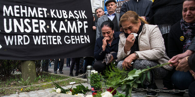 Zwei Frauen hocken vor einem Grabstein und trocknen ihre Tränen mit Taschentüchern. Es sind Angehörige des vom NSU ermordeten Kioskbesitzer Mehmet Kubasik. Zwei Frauen hocken vor einem Grabstein und trocknen ihre Tränen mit Taschentüchern. Es sind Angehörige des vom NSU ermordeten Kioskbesitzer Mehmet Kubasik.