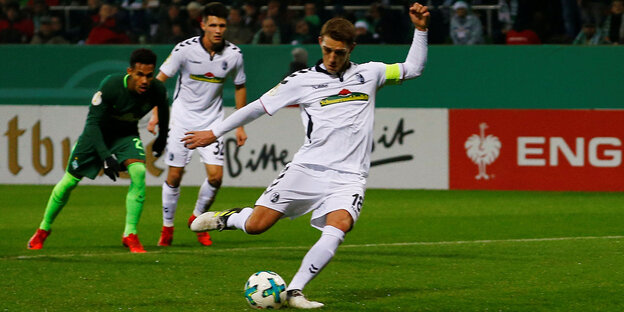 Fußballer in weiß beim Strafstoß Fußballer in weiß beim Strafstoß