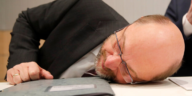 SPD-Chef martin Schulz legt den Kopf auf einen Tisch SPD-Chef martin Schulz legt den Kopf auf einen Tisch