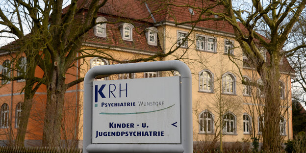 Ein Schild mit dem Schriftzug "Psychiatrie Wunstorf" steht vor einem großen alten Gebäude. Ein Schild mit dem Schriftzug "Psychiatrie Wunstorf" steht vor einem großen alten Gebäude.
