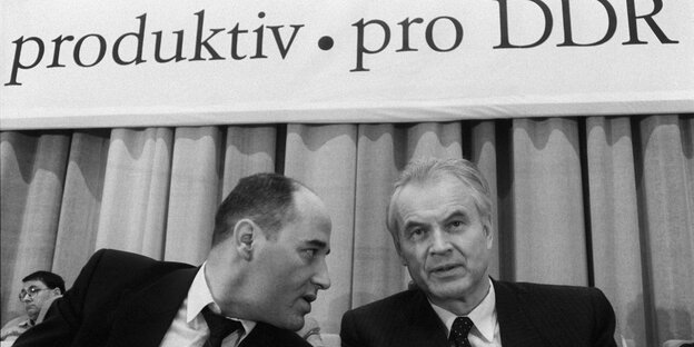 Der DDR Anwalt Gregor Gysi im Gespräch mit dem Vorsitzenden des DDR-Ministerrates, Hans Modrow. Im Hintergrund ist der Schriftzug "produktiv, pro DDR" zu sehen. Der DDR Anwalt Gregor Gysi im Gespräch mit dem Vorsitzenden des DDR-Ministerrates, Hans Modrow. Im Hintergrund ist der Schriftzug "produktiv, pro DDR" zu sehen.