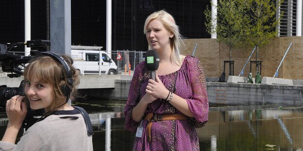 Eine Fernsehreporterin mit Kamerafrau Eine Fernsehreporterin mit Kamerafrau