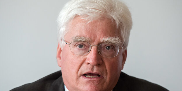 Ein älterer Mann mit weißen Haaren, weißen Augenbrauen und einer runden Brille. Ein älterer Mann mit weißen Haaren, weißen Augenbrauen und einer runden Brille.