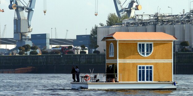 Ein gelbes Hausboot fährt durch den Hamburger Hafen. Ein gelbes Hausboot fährt durch den Hamburger Hafen.