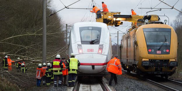 Auf der freien Strecke steckengebliebener ICE mit Bergungsarbeitern und einem Kranzug auf dem Nachbargleis Auf der freien Strecke steckengebliebener ICE mit Bergungsarbeitern und einem Kranzug auf dem Nachbargleis