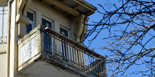Ein Balkon an dem der Putz bröckelt und sich Moos angesetzt hat. Ein Balkon an dem der Putz bröckelt und sich Moos angesetzt hat.