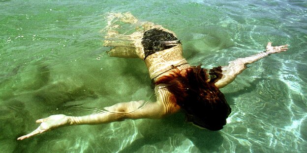 Eine Frau schwimmt unter Wasser Eine Frau schwimmt unter Wasser