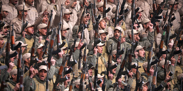 Viele Männer, die etwas rufen und Waffen hochhalten Viele Männer, die etwas rufen und Waffen hochhalten